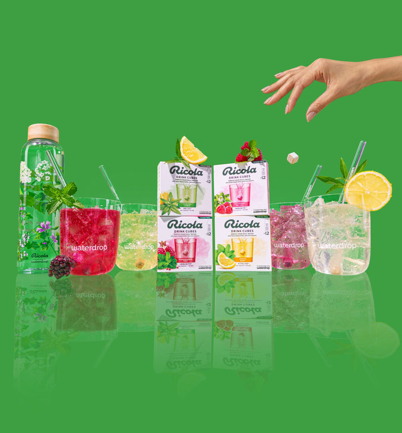 Ricola flavours in Glasses. A hand in the top right corner is dropping a drink cube into a glass.